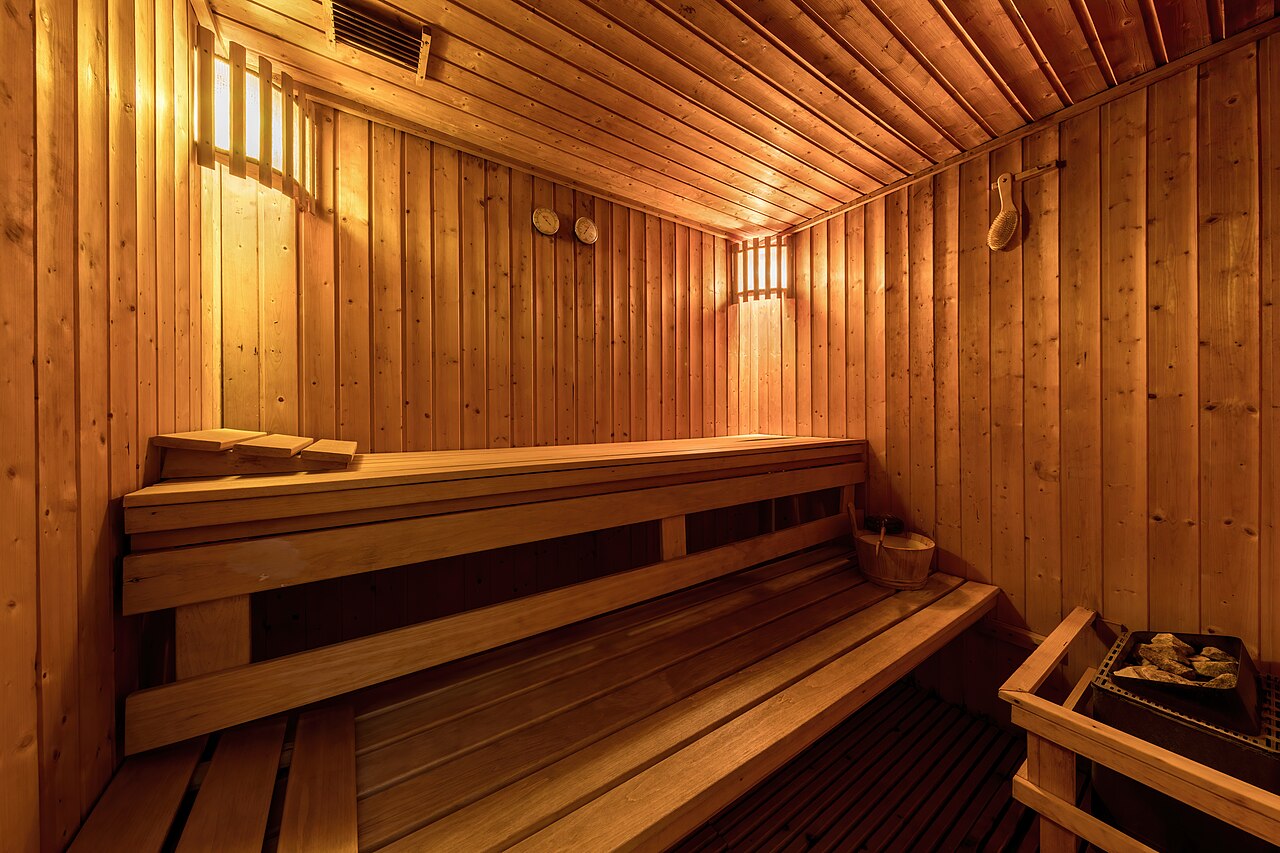 Interior de sauna con bancos de madera y estufa